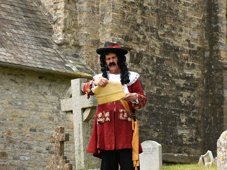 An image of the town crier holding a scroll